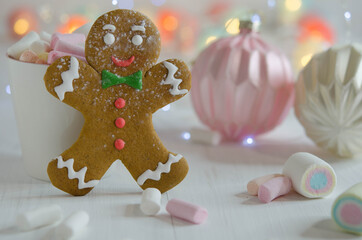 Cup with marshmallows and gingerbread man on a blurred background.