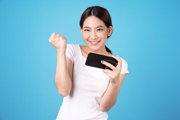 Asian woman holding a smartphone in hand, Isolated on a blue background.