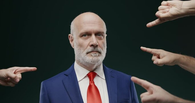 Many fingers pointing at one guilty businessman