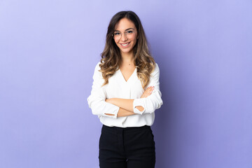 Young caucasian woman isolated on purple background keeping the arms crossed in frontal position
