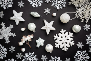 Christmas holidays composition with white christmas decorations and snowflakes on black background with copy space for your text