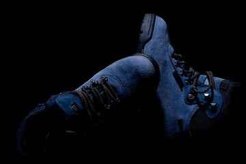 Fototapeta na wymiar Blue winter boots on black background. Trekking boots perfect for winter time. Close up.