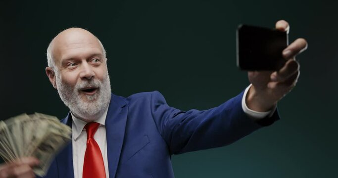 Businessman taking a selfie while holding cash money