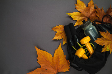 Bottle of water, dumbbells and jumping rope (or skipping rope) in a training bag. Workout equipment...