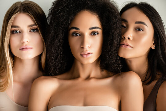 close up of young interracial models looking at camera isolated on white