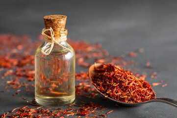 Glass bottle of saffron essential oil on rustic background, spice or herb oil concept, alternative...