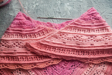 Crochet background flatlay. Crochet hook and scarf on a concrete background