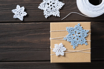 Idea gifts wrapping of the Christmas gift and decoration with knitted snowflakes.