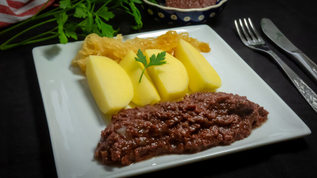 traditionelle Grützwurst mit Kartoffelecken und Sauerkraut modern angerichtet