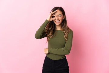 Young caucasian woman isolated on pink background showing ok sign with fingers