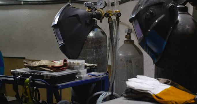 Work in the workshop for the manufacture of tin products. Tracking shot near welding equipment, gas cylinders and protective masks.  4K 50 fps slow motion