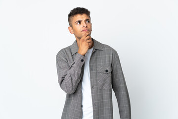 Young brazilian man isolated on white background having doubts