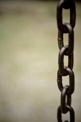 Long faded black rusty chain at public park