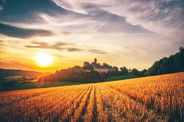 The Ronneburg in Germany in a great landscape photo. Beautiful fields with a castle and in the sunset

