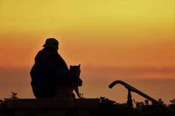 Silhouette of sunrise / old man and dog