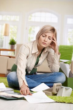 Woman checking bills and financial situation at home