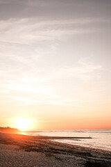 puesta de sol naranja sobre playa francesa, en las isla de re.