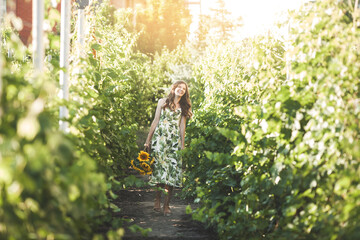 Lady outdoors. Woman with sunflowers.