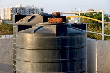 Big water tank with brick on container cover on top of roof top