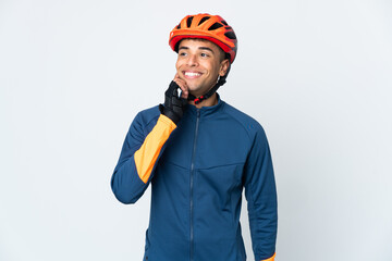 Young cyclist Brazilian man isolated on white background thinking an idea while looking up