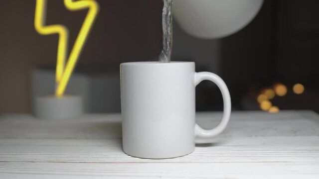 White mug that you can add your custom design to. Pouring hot water from kettle.