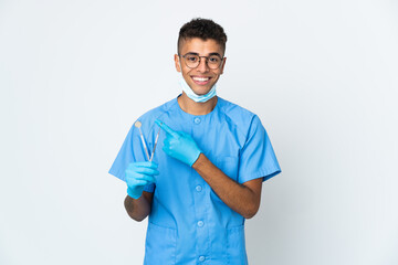 Brazilian dentist holding tool isolated on white background pointing to the side to present a product