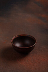 One dark cup on brown background