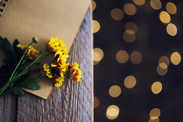 Autumn still life. Old vintage notebook with yellow flowers. Toned image. Flat lay, top view, copy space.