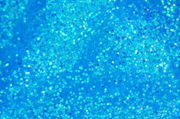Naklejka na ściany i meble Blue glitters in liquid. Abstract festive background with sparkles and bokeh.