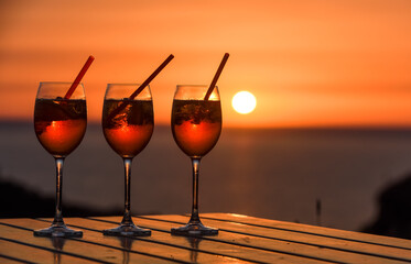 Three glasses of the famous Italian cocktail  spritz aperol against the background of sunset