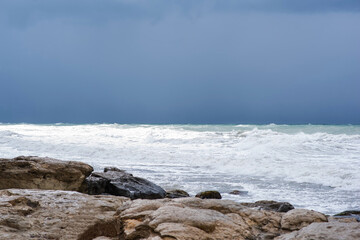 Autumn sea landscape. Rough sea with waves during autumn stormy weather. Dark heavy clouds in the sky. Dark and dramatic storm clouds background.
