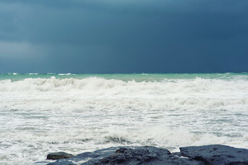 Autumn sea landscape. Rough sea with waves during autumn stormy weather. Dark heavy clouds in the sky. Dark and dramatic storm clouds background.