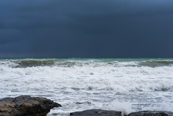 Autumn sea landscape. Rough sea with waves during autumn stormy weather. Dark heavy clouds in the sky. Dark and dramatic storm clouds background.