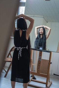 Beautiful Asian Woman Looking Into The Mirror