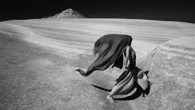 Woman In Motion With A Face Hidden In A Desert.