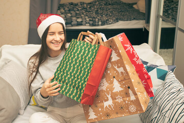 Gifts for Christmas and new year. A young woman takes a present from a bag with winter patterns