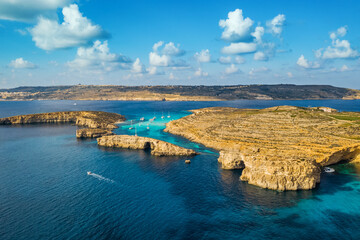 Aerial drone top view of Comino island, Blue lagoon and boats, caves. Malta island