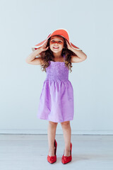 Beautiful fashionable little girl in a dress and mom's shoes