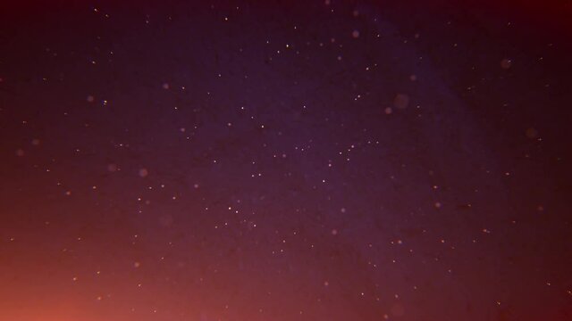 An orange blue gradient motion background with flickering specks dust and stars floating away, which is perfect for Christmas or holiday based themes that incorporate snow or warm visuals like this