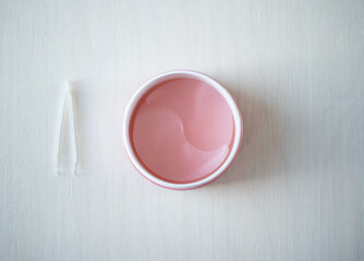 Pink hydrogel eye patches оn a light background. Bathroom treatments. Homemade face care.