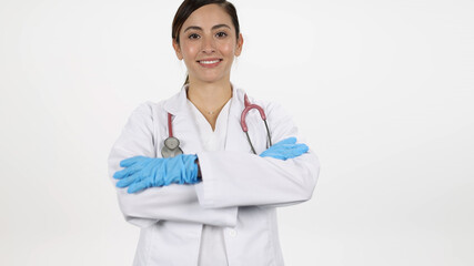 Female doctor turning and folding arms while smiling moving in towards them on white background.