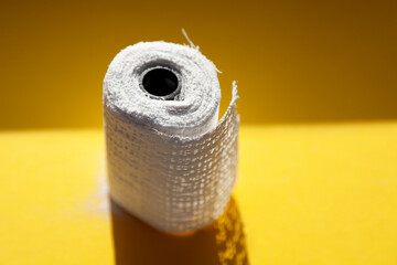 a roll of plaster band on yellow background in sunshine