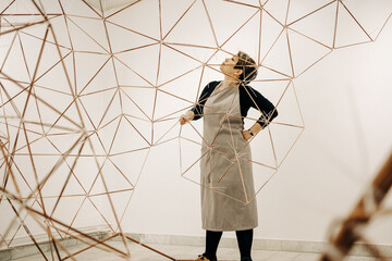 Woman Artist Assembling A Large Metal Sculpture