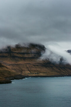 Rough rocky coast with fog and cloudy sky