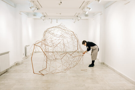 Female Sculptor Working On The Abstract Metal Sculpture In The Gallery