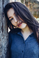 Portrait of beautiful girl. Pretty girl with long dark hair and red lips. Portrait of young stylish girl in the park in sunny day. Conceptual fashion style.