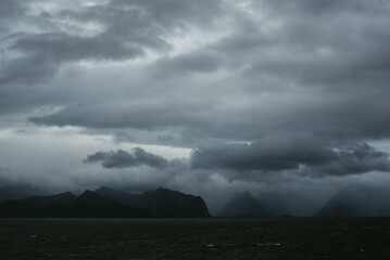 Scenic landscape of heavy clouds and silhouettes of mountains