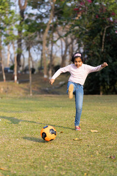 Girl playing with soccer ball on the field