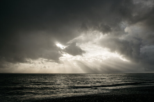 Stormy sea against sunlight breaking through an overcast sky