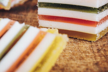Multicolored striped marmalade close-up on wooden table. Colorful jelly candy close-up. Macro shot, selective focus.